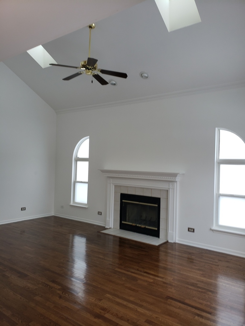 334 Spring Valley Way Round Lake, IL 60073 - Photo 11 of 26 an empty room with wooden floor fireplace and windows