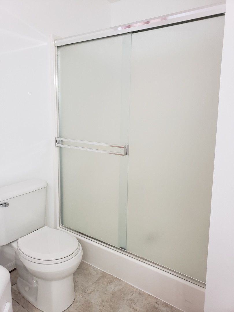 334 Spring Valley Way Round Lake, IL 60073 - Photo 17 of 26 a bathroom with a toilet and a shower curtain