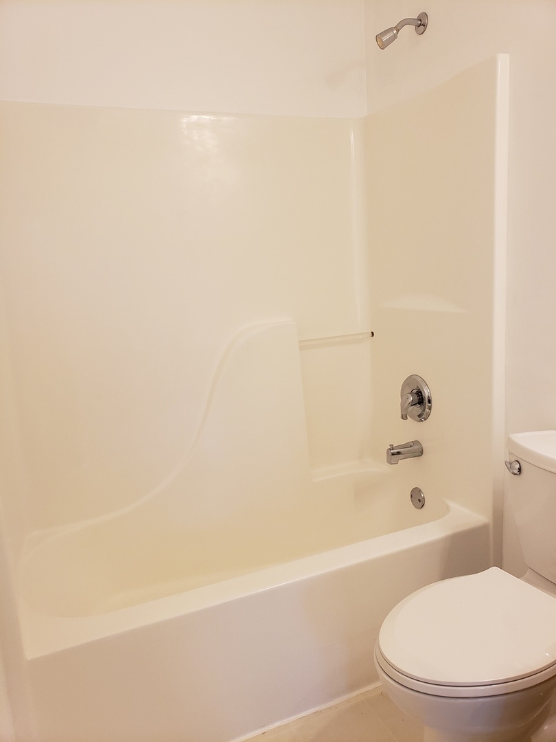 334 Spring Valley Way Round Lake, IL 60073 - Photo 21 of 26 a white toilet sitting next to a bath tub