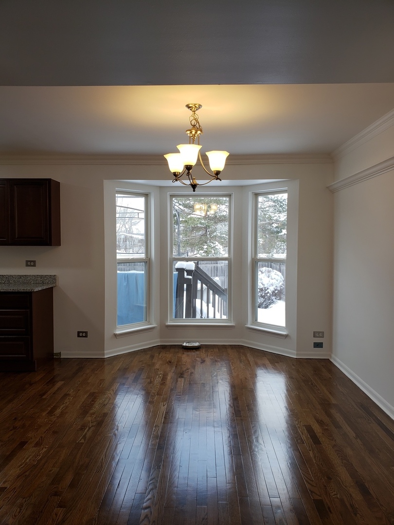 334 Spring Valley Way Round Lake, IL 60073 - Photo 5 of 26 a view of an empty room with wooden floor and a window