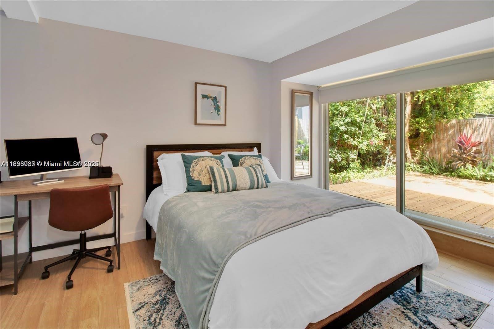 833 West 39th Street, Unit 5 Miami Beach, FL 33140 - Photo 7 of 12 a bedroom with a bed a large window and chair