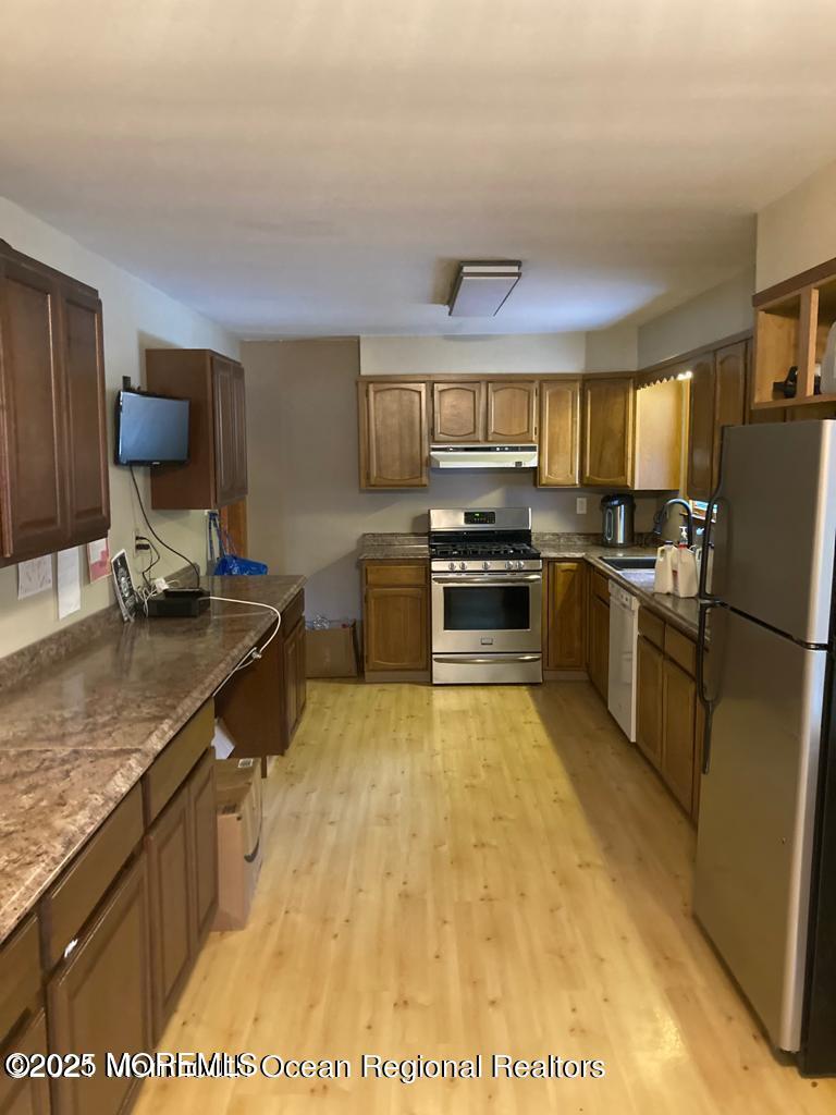 2 Lloyd Place Oakhurst, NJ 07755 - Photo 2 of 4 a kitchen with stainless steel appliances granite countertop a sink stove microwave and refrigerator