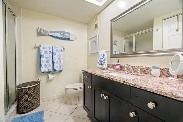 a bathroom with a granite countertop double vanity sink and a mirror