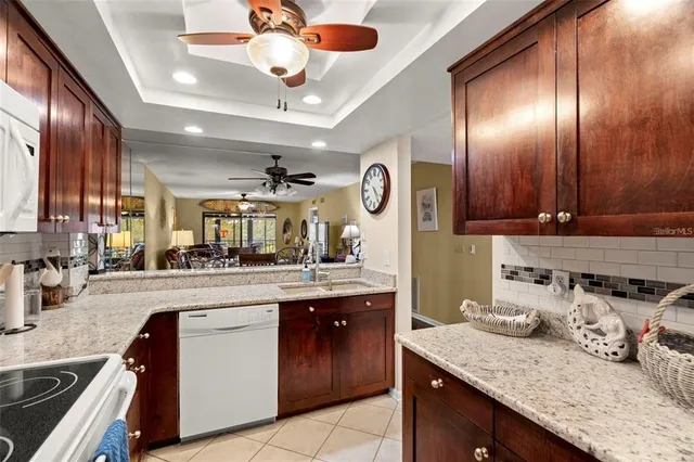 a kitchen with granite countertop stainless steel appliances a sink stove and cabinets