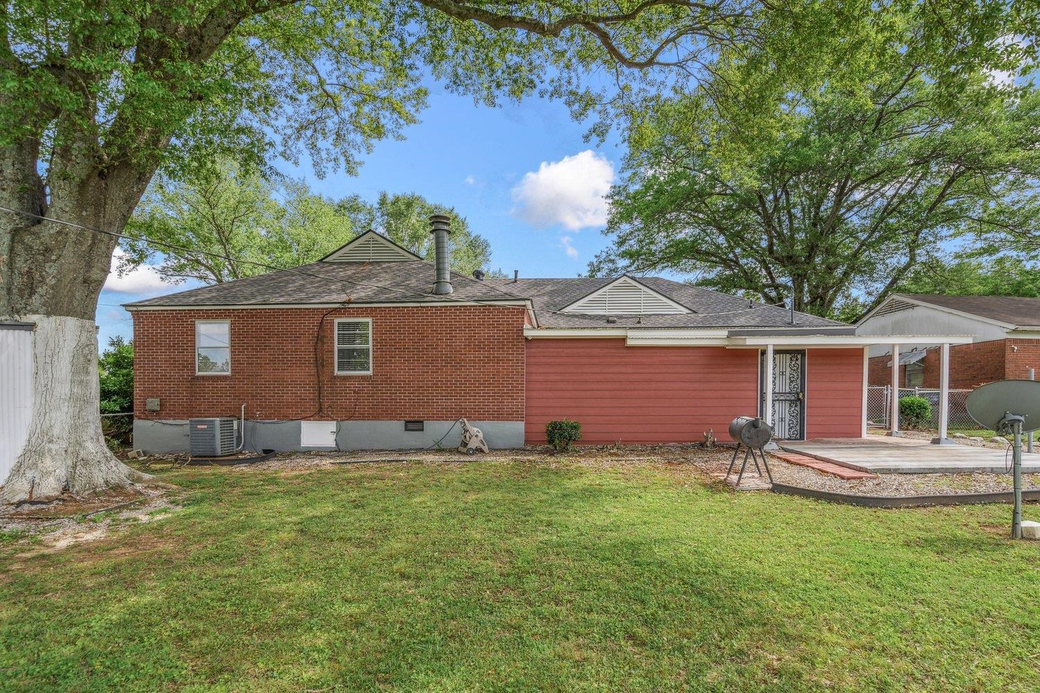 5040 Warrington Road Memphis, TN 38118 - Photo 28 of 29 Rear view of house featuring a yard, a shingled roof, a patio, and crawl space