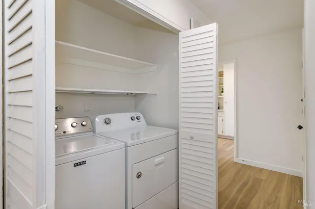 a view of washer and dryer with bathroom in the background