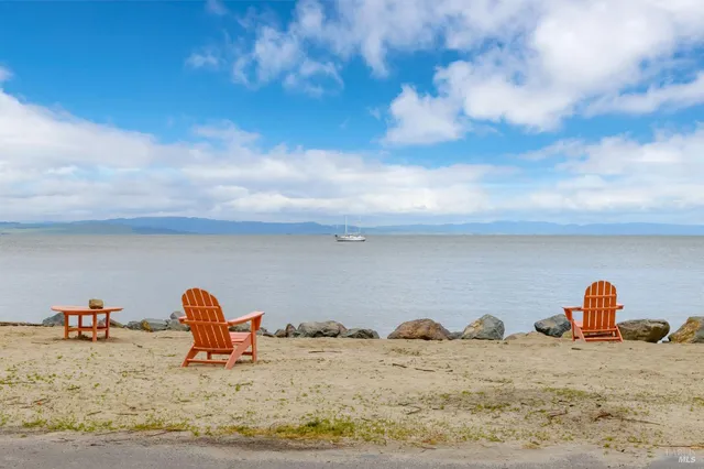 a front view of a house with a yard and potted plants