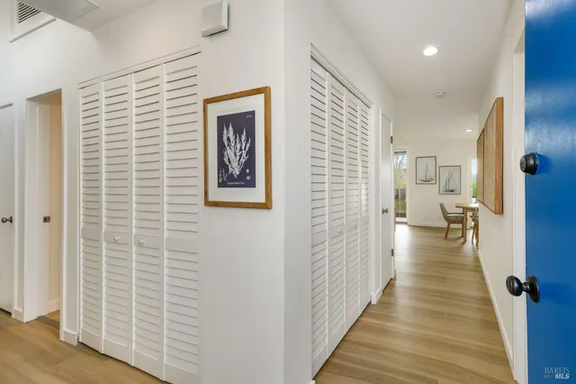 a view of a hallway with wooden floor and staircase