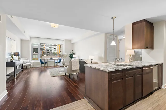 a living room with granite countertop kitchen island wooden floor and white appliances
