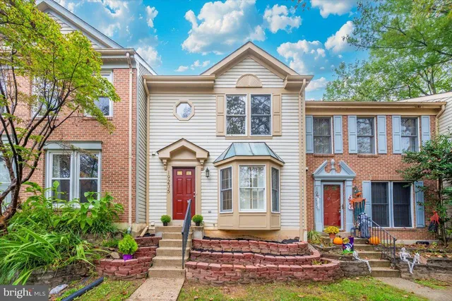 a front view of a house with yard and trees