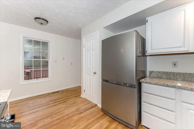 a kitchen with granite countertop a refrigerator and a sink
