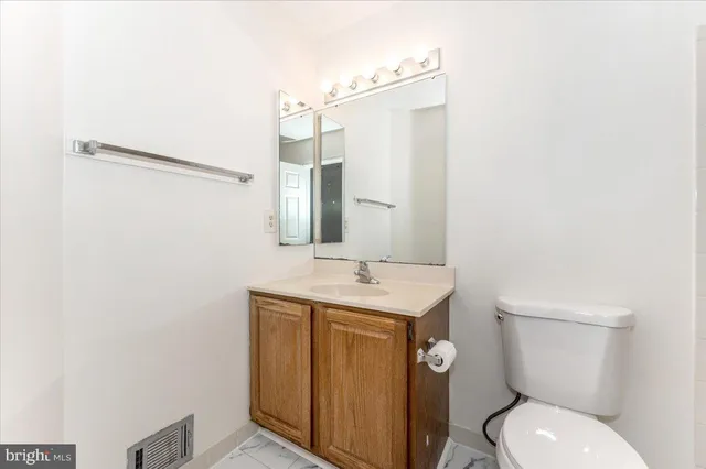 a bathroom with a toilet a sink and mirror