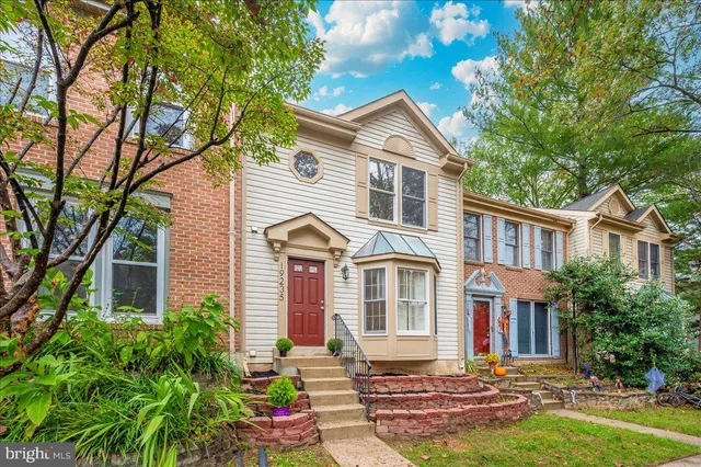 a front view of a house with yard and green space