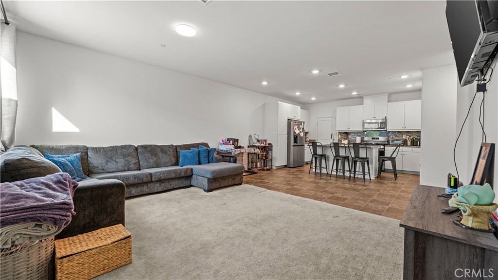 5604 Altamura Way, Unit 8 Fontana, CA 92336 - Photo 5 of 18 a living room with furniture and a dining table with kitchen view