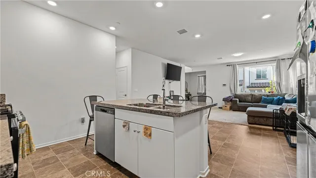 a kitchen with stainless steel appliances granite countertop a sink and a refrigerator