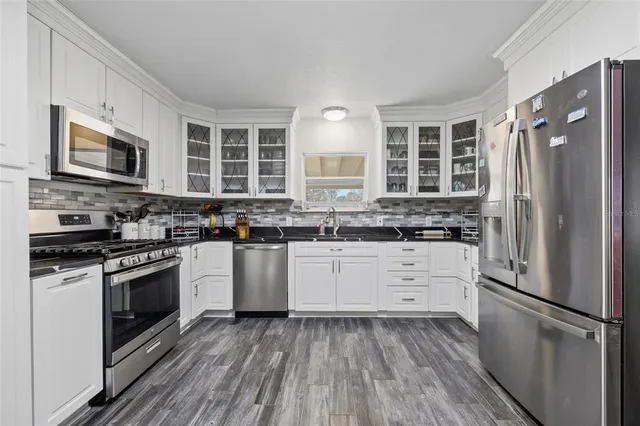 a kitchen with stainless steel appliances a refrigerator sink and microwave