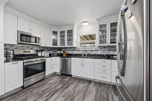 a kitchen with stainless steel appliances a stove a sink and a microwave