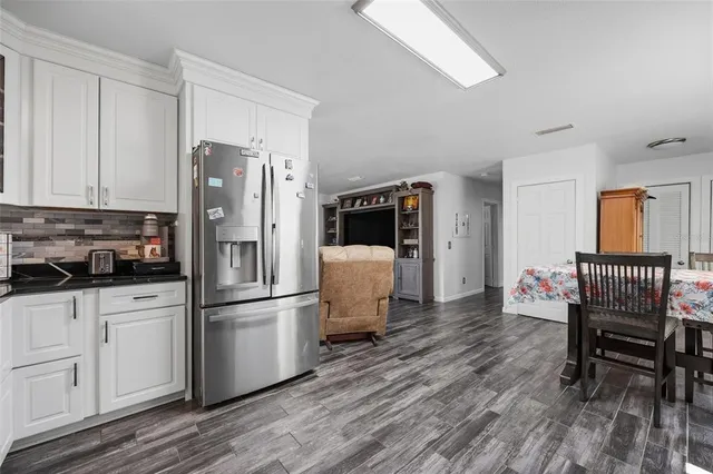 a kitchen with stainless steel appliances a refrigerator and wooden floor