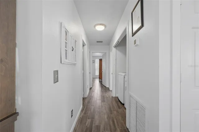a view of a hallway with wooden floor
