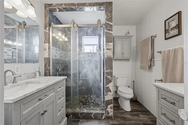 a bathroom with a granite countertop sink toilet and shower