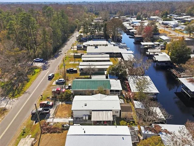 an aerial view of a house with a yard and large trees
