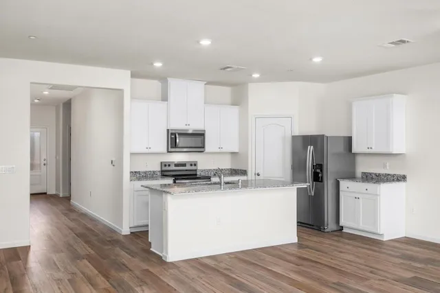 a kitchen with stainless steel appliances a refrigerator and a stove top oven