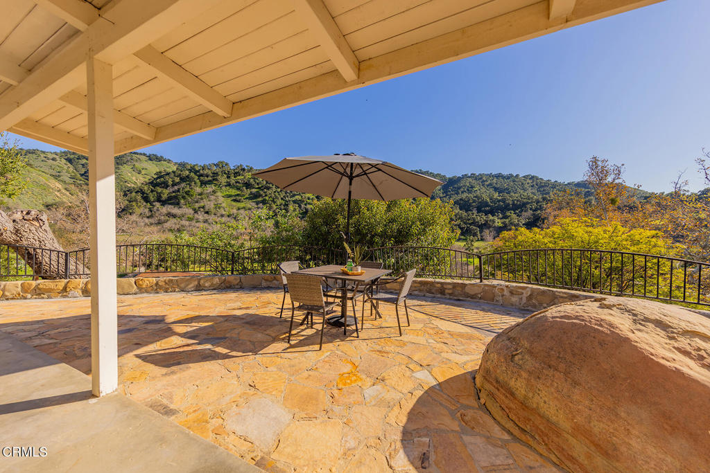 10522-62 Creek Road Ojai, CA 93023 - Photo 4 of 20 a view of a swimming pool with a table and chairs under an umbrella
