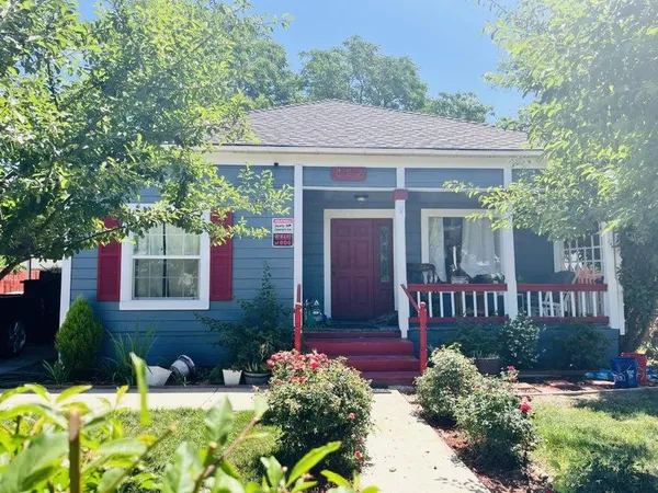 a view of a house with brick walls and flower plants