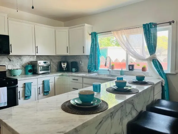 a kitchen with a stove a sink and a white cabinets