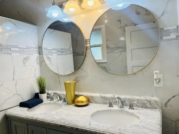 a bathroom with a granite countertop sink a mirror and vanity