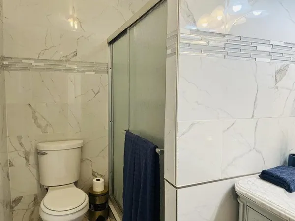 a bathroom with a shower a toilet and a sink