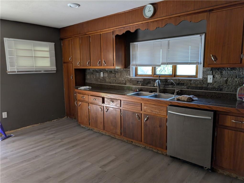 9701 Wilson Street Irwin, PA 15642 - Photo 7 of 20 a kitchen with stainless steel appliances granite countertop wooden cabinets a stove a sink and dishwasher with wooden floor