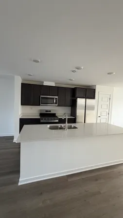 a living room with stainless steel appliances kitchen island a stove and a refrigerator