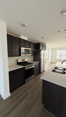 a kitchen with stainless steel appliances kitchen island granite countertop a stove a sink and a refrigerator