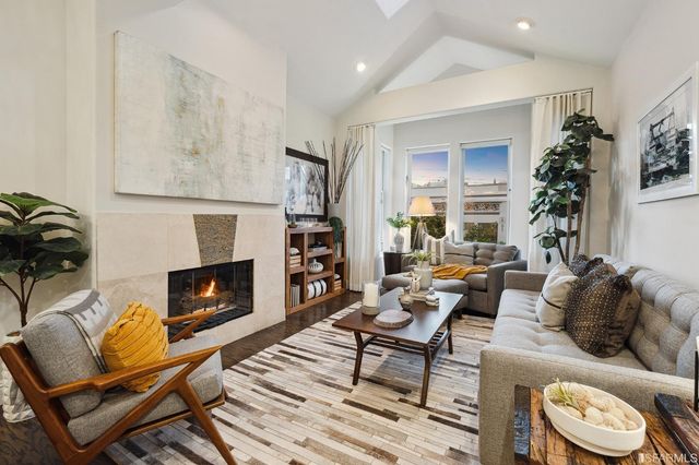 a living room with furniture fireplace and potted plants