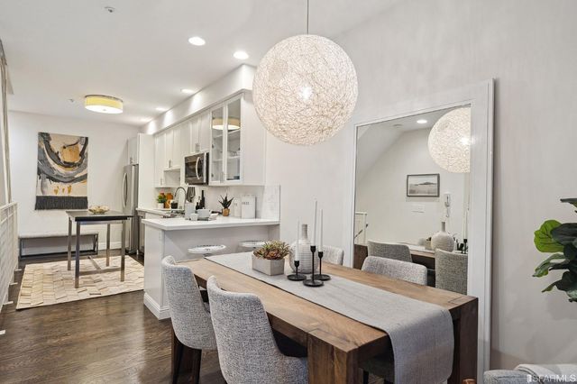 a dining room with wooden floor and chandelier