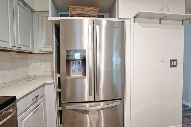 a metallic refrigerator freezer sitting in a kitchen