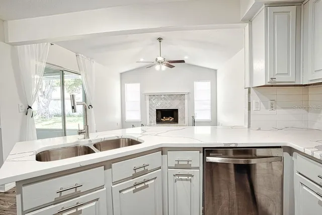 a kitchen with granite countertop a sink and white cabinets