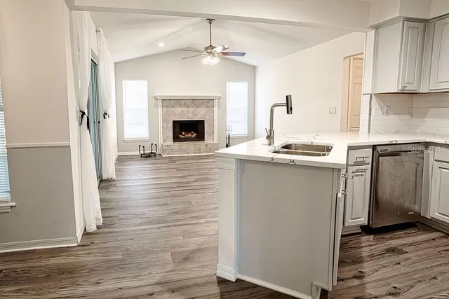 a kitchen with granite countertop a sink stove and cabinets