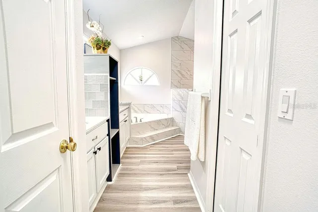 a view of a hallway with wooden floor and staircase