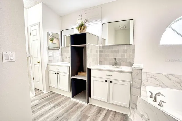 a spacious bathroom with a shower sink and mirror