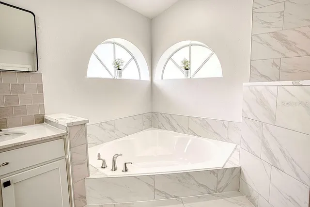 a white bath tub sitting next to a window