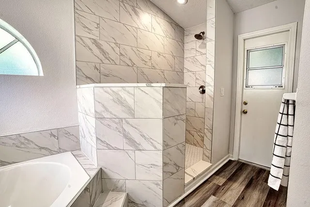 a bathroom with a tub and shower