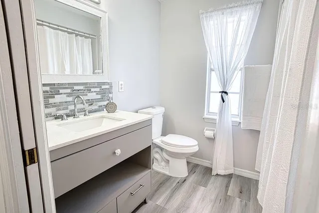 a bathroom with a toilet sink and a mirror