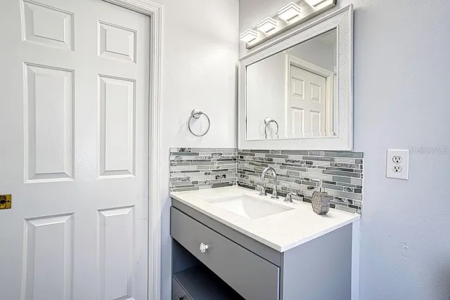 a bathroom with a sink vanity and a mirror