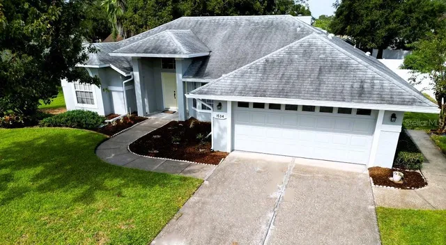 an aerial view of a house with a yard and large trees