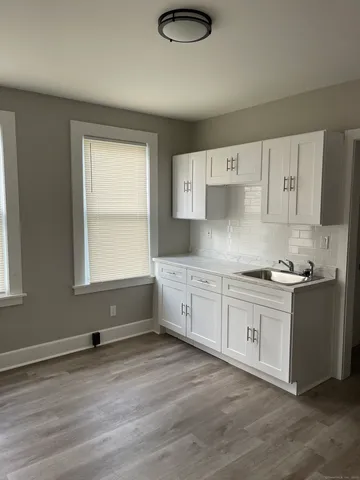 a kitchen with granite countertop white cabinets and white appliances