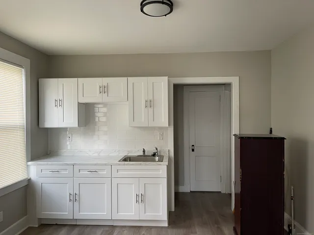 a kitchen with granite countertop white cabinets and white appliances