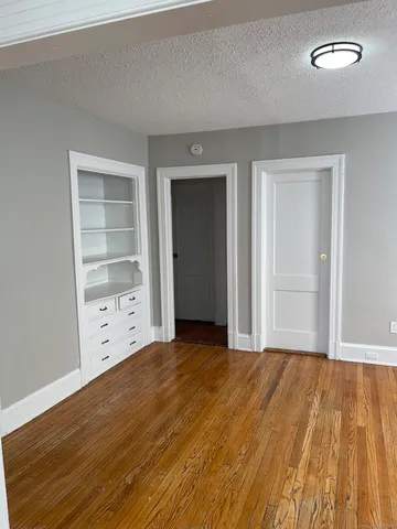 a view of an empty room with closet and a window