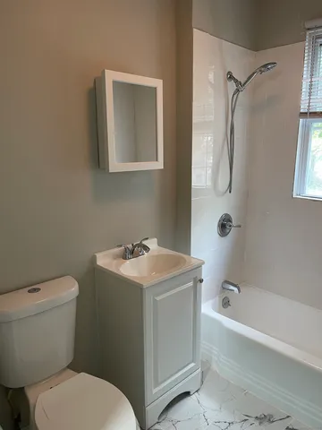 a bathroom with a toilet sink and mirror